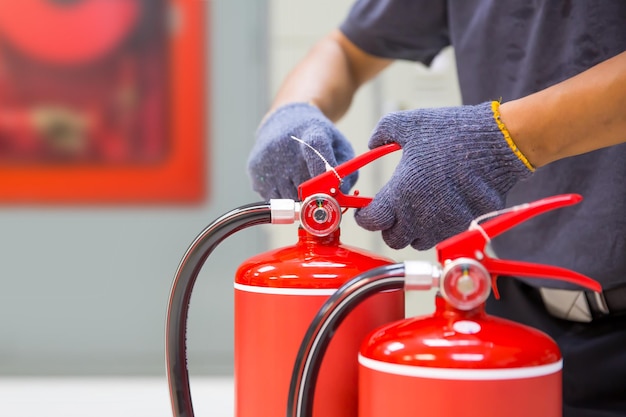 Extintor de incêndio tem alça de verificação de inspeção de engenheiro preparar equipamentos de incêndio para proteção e evitar resgate de emergência e segurança e conceito de treinamento do sistema de alarme