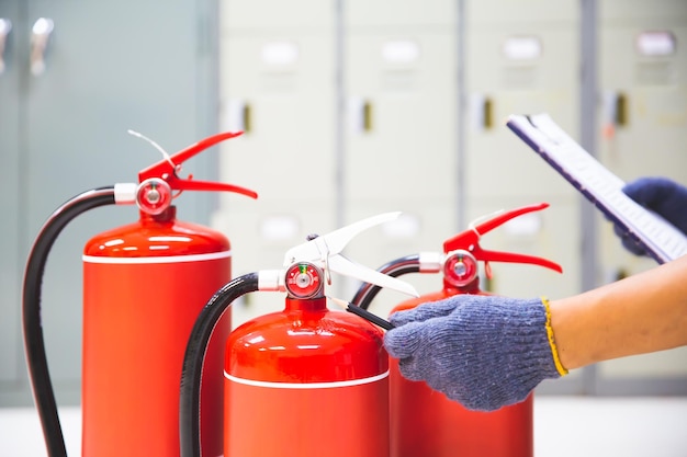 Extintor de incêndio tem engenheiro de mão verificando medidores de pressão