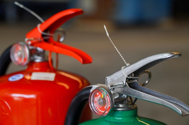 Extintor de incêndio vermelho e tanques verdes para uso em emergências industriais conceito de prevenção de incêndio