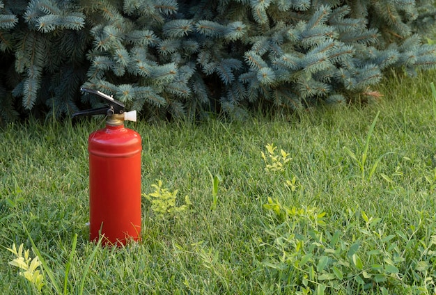 extintor de incêndio vermelho na grama verde