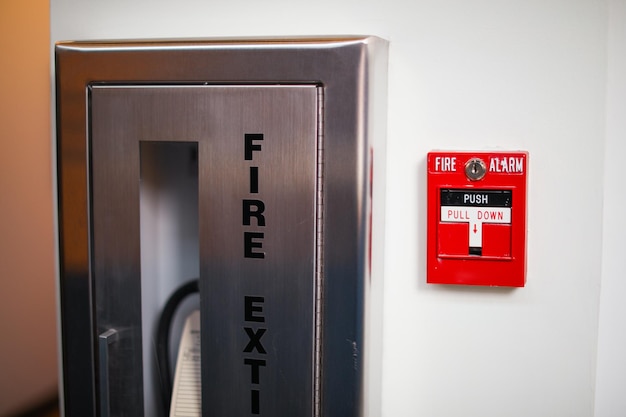 Foto un extintor de incendios está en la pared al lado de un extintor de incendios.