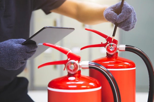 El extintor de incendios tiene un ingeniero manual revisando los manómetros