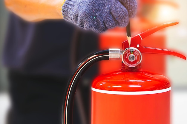 El extintor de incendios tiene la inspección manual del ingeniero comprobando los medidores de presión