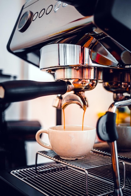 Extração de café da máquina de café com um porta-filtro despejando café em uma xícara