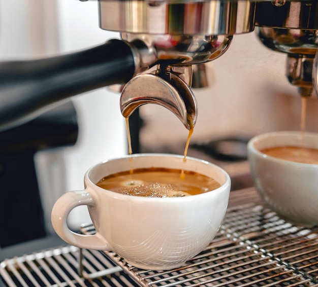 Extração de café da máquina de café com um portafiltro, derramando café numa chávena