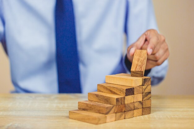 Extracción manual o colocación de bloques de madera en la torre, plan y estrategia en los negocios