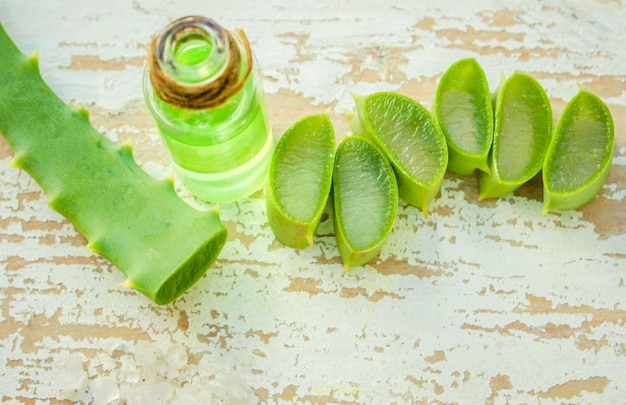 Extracto de Aloe Vera en una pequeña botella y piezas sobre la mesa. Enfoque selectivo