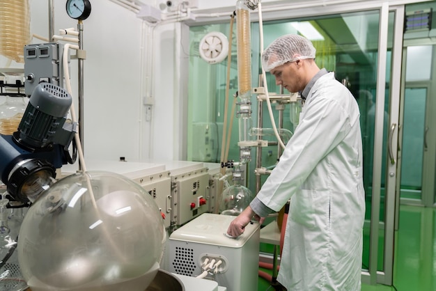 Foto extracto de boticario científico usando máquina de extracción de cannabis en laboratorio