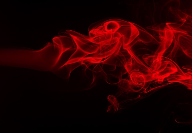 Extracto rojo del humo en fondo negro. diseño de fuego