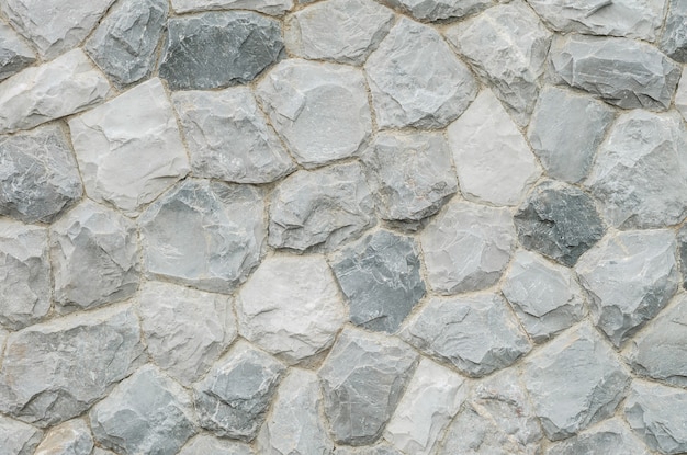 Foto el extracto superficial del primer en la pared de piedra vieja en el jardín texturizó el fondo