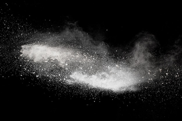 Extrañas formas de polvo blanco nube de explosión contra el fondo negro. Salpicaduras de partículas de polvo blanco.