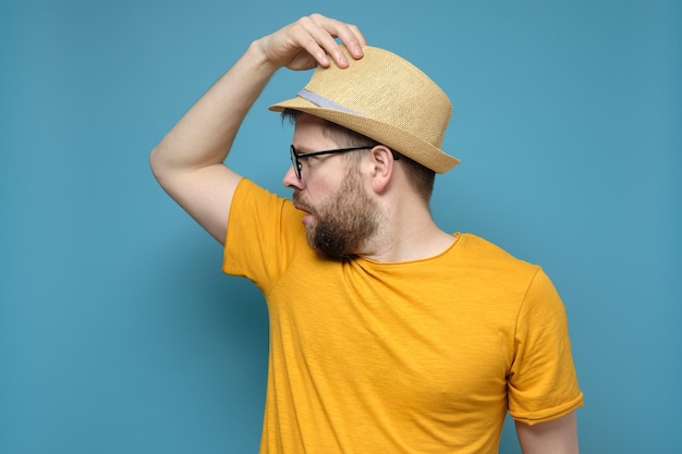 Un extraño hombre confundido con un sombrero de paja hace un gesto de saludo y la sorpresa mira hacia otro lado