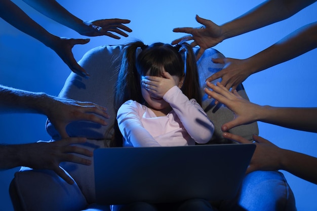 Foto extraños alcanzando a un niño pequeño asustado con una computadora portátil sobre fondo de color peligro cibernético