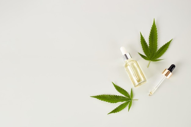 Extrato de óleo cbd de óleo essencial de cannabis em frasco conta-gotas com folha verde de cannabis marijuana maconha medicinal planta de fitoterapia espaço para texto