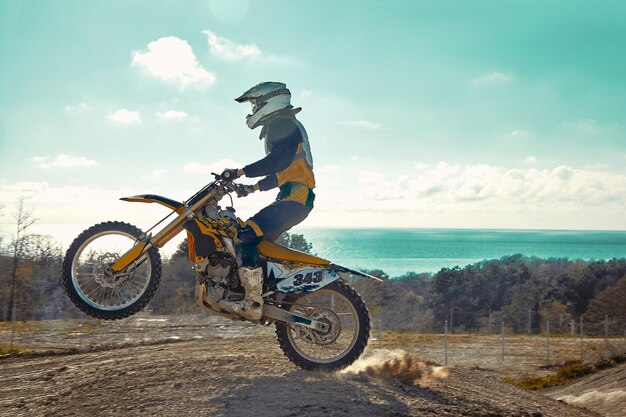 Extreme Konzept Herausforderung selbst Extreme Sprung auf einem Motorrad auf einem Hintergrund des blauen Himmels mit Wolken Kopieren Sie den Raum alles oder nichts