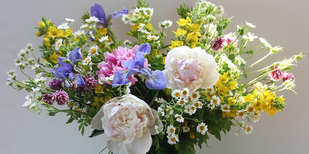 Exuberante ramo de verano con peonías, lirios, margaritas y otras flores como telón de fondo de fondo floral