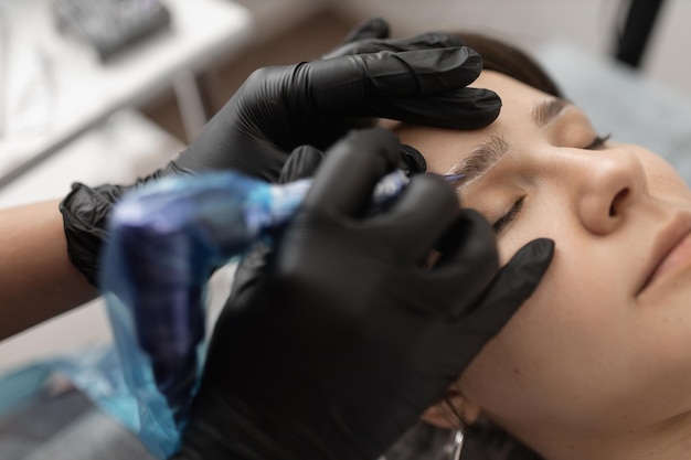 Eyebrow master tatúa nuevas cejas para una clienta