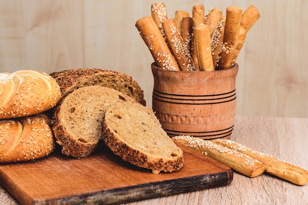 ÃƒÂ Ã‚Â¡risp pão com pãezinhos. Baguetes francesas. Pão estaladiço fresco. Fundo de pão. Raça diferente em fundo de madeira.