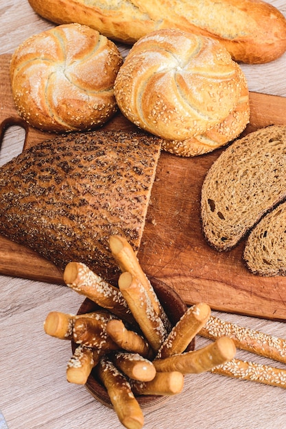 ÃƒÂ Ã‚Â¡risp pão com pãezinhos. Baguetes francesas. Pão estaladiço fresco. Fundo de pão. Raça diferente em fundo de madeira.