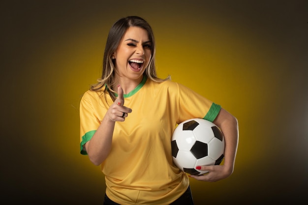 Fã brasileira fã brasileira comemorando no futebol ou partida de futebol em fundo amarelo cores do brasil