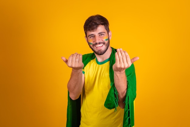 Fã brasileiro comemorando em fundo amarelo a Copa do Mundo 2022