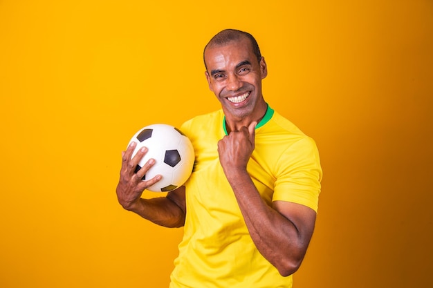 Fã brasileiro comemorando em fundo amarelo com espaço livre para texto