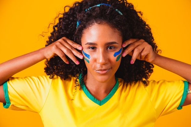 Fã brasileiro. usando tinta como maquiagem, torcedor brasileiro celebrando futebol ou jogo de futebol. Cores do Brasil.