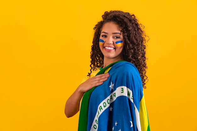 Fã brasileiro vestindo bandeira brasileira em um retrato Fã brasileiro comemorando jogo de futebol ou futebol em fundo amarelo Cores da Copa do Mundo do Brasil