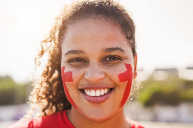 Fã de esporte vermelho olhando para a câmera fora do estádio antes do jogo de futebol Foco no rosto