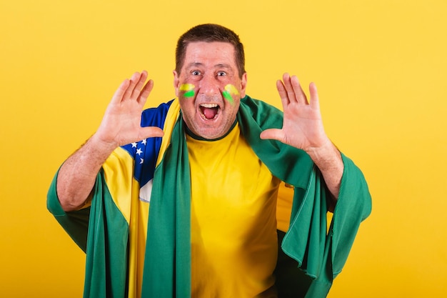 Fã de futebol adulto do brasil usando bandeira gritando foto publicitária de promoção