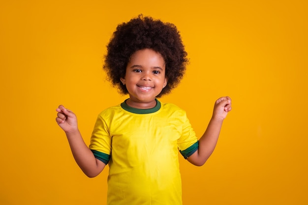 Fã de futebol brasileiro de garotinha com os dedos cruzados torcendo pelo brasil