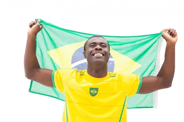 Fã de futebol brasileiro feliz torcendo bandeira de espera