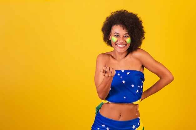 Fã de futebol brasileiro jovem negra convidando com as mãos chamando