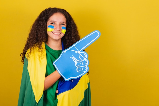 Fã de futebol caucasiano brasileiro com mão de espuma torcendo por fã de futebol da copa do mundo roupas de fã brasileiro