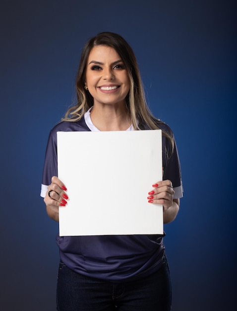 Fã de futebol feminino torcendo por seu clube favorito e equipe de fundo azul da copa do mundo segurando cartão branco em branco