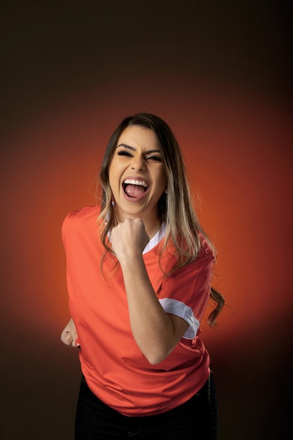 Fã de futebol feminino torcendo por seu clube favorito e time de fundo laranja da copa do mundo