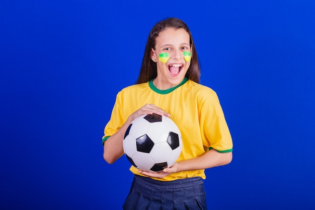 Fã de futebol jovem do Brasil segurando uma bola de futebol