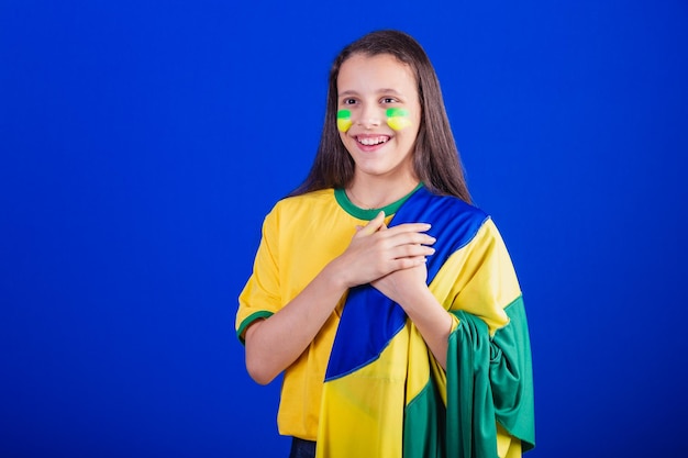 Fã de futebol jovem do brasil vestido com bandeira cantando o hino nacional gratidão