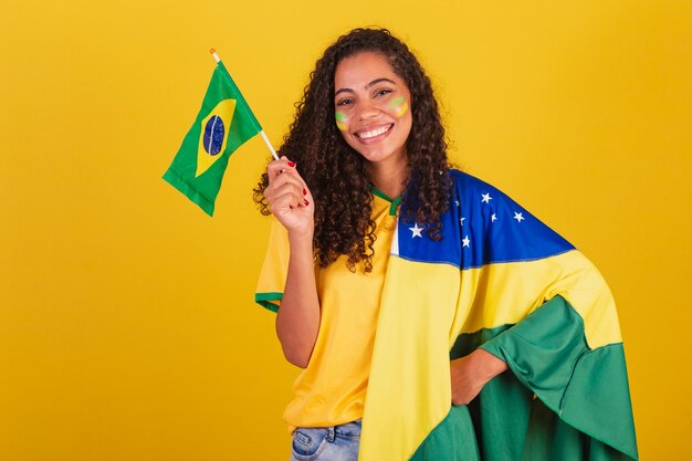 Fã de futebol jovem negra brasileira acenando bandeira nacionalista patriótica