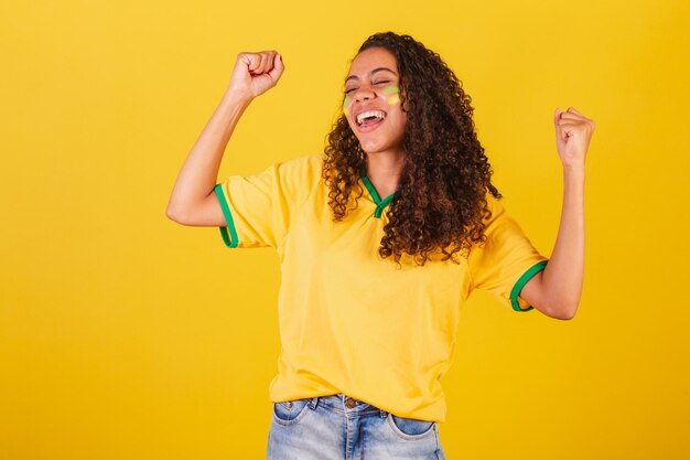 Foto fã de futebol jovem negra brasileira comemorando e comemorando