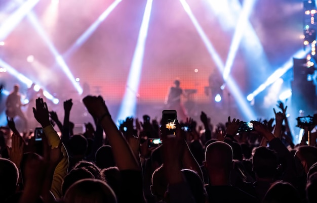 Fã de música gravando vídeo no telefone na multidão no festival de concertos