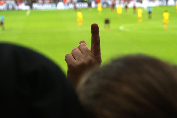 Foto fã fazendo um gesto enquanto assiste futebol no estádio