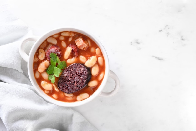 Fabada española en mesa blanca cerrar