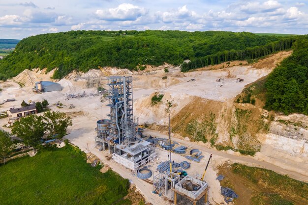 Fábrica de cemento en minería a cielo abierto de materiales de piedra arenisca de construcción con excavadoras y camiones volquete