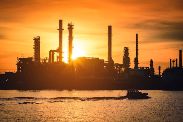 Fábrica de la fábrica de la refinería de petróleo y gas de la silueta con el cielo hermoso en la salida del sol.