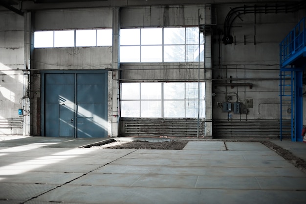 Fábrica de fabricación rusa. Edificio de hangar vacío. Fondo de tonos azules.