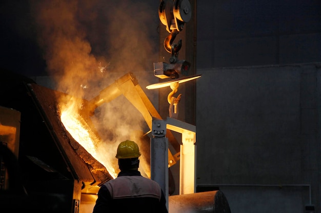 Foto fábrica de fundición y trabajador.