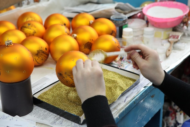 Foto fábrica de juguetes navideños el trabajador sopla el vidrio la b