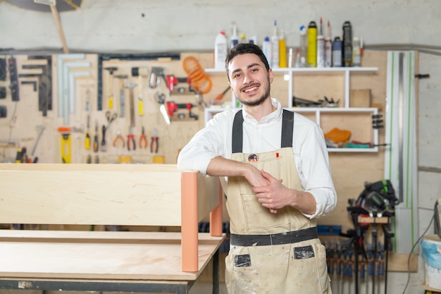 Fábrica de muebles, pequeñas empresas, concepto de negocio - trabajador en la producción de muebles.