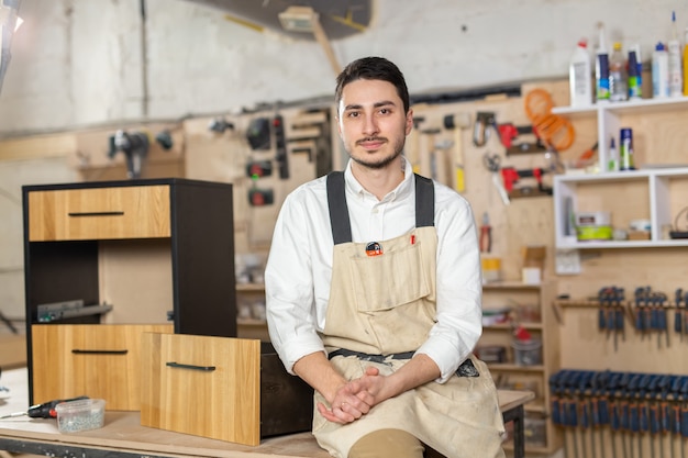 Fábrica de muebles, pequeñas empresas y concepto de personas - Retrato de un trabajador masculino sonriente en